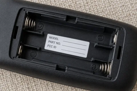 Illustrative close-up of an empty battery compartment with its identification label inside.
